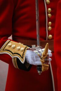 Close-up of a British guard in traditional uniform holding a ceremonial sword.