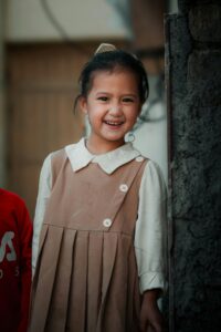 Smiling school girl in uniform ready for her private home tuition class.