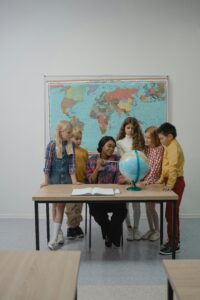 A female teacher explaining the world globe to school children during a home tutoring session in Islamabad