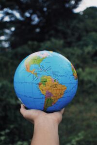 A hand holding a globe representing the global reach and accessibility of online tutoring.