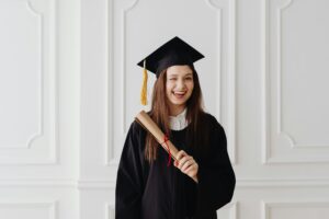 Confident girl in graduation gown holding a certificate after achieving academic success with private home tuition.