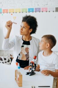 Teacher and student examine test tube in science class.