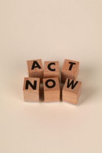 Wooden blocks with 'ACT NOW' message encouraging action on a neutral background.