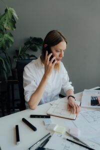 Professional woman in an office making a business call, consulting about academy enrollment and home tutor placement, City Home Tutors support