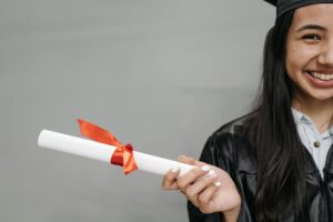 Happy young girl holding a rolled university degree smiling with confidence representing the value of formal education and academic success in Pakistan supported by City Tutors Academy